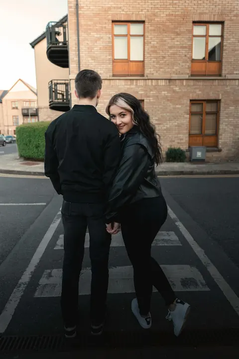 Pareja abrazada cruzando una calle