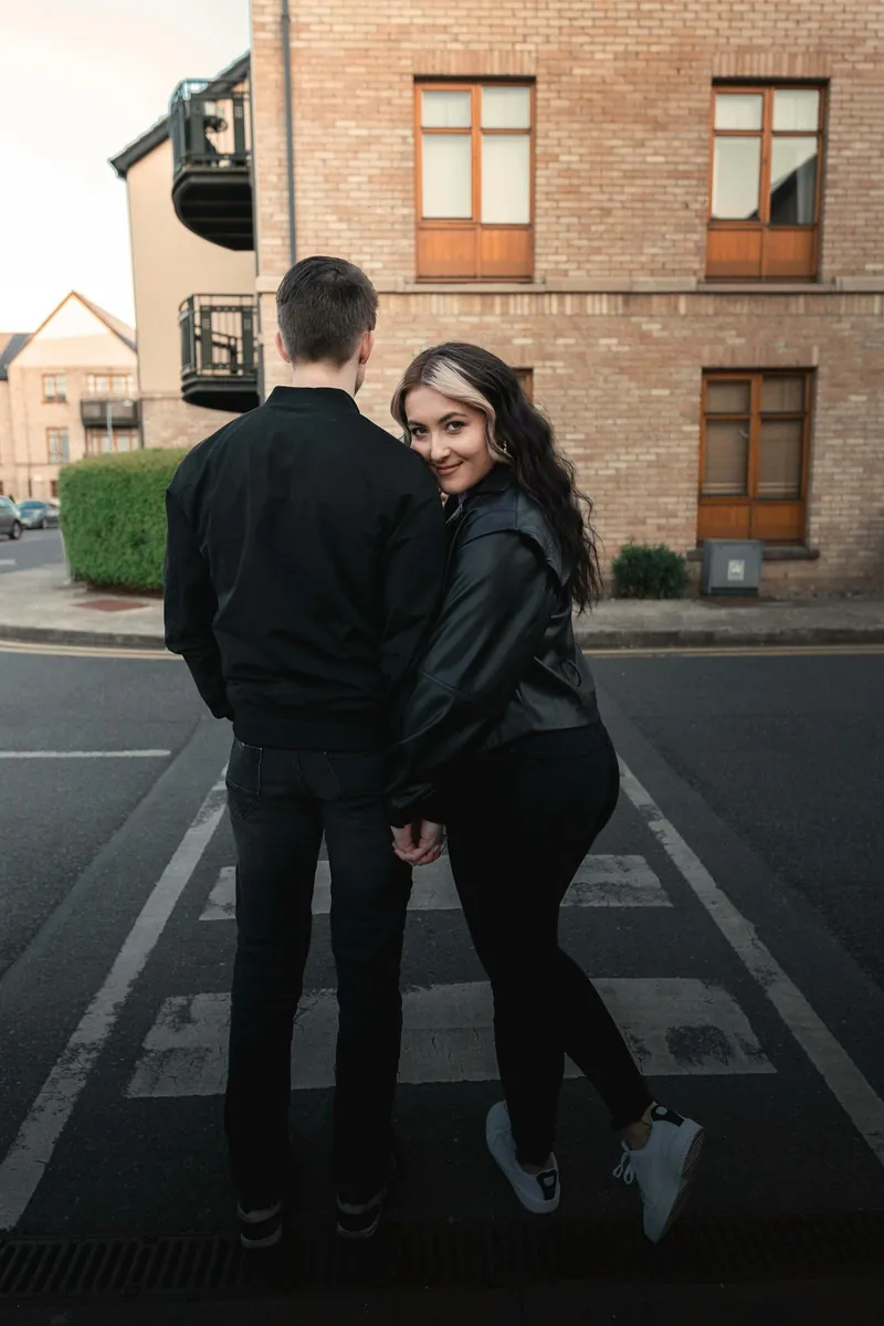 Pareja abrazada cruzando una calle